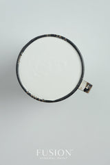 Black mug with white liquid, placed on white surface; Sterling Fusion Mineral Paint in Sterling color shown below.