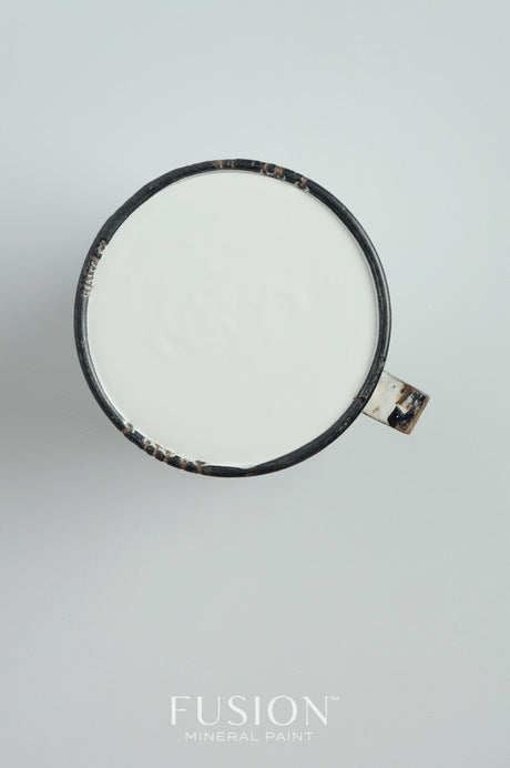 Black mug with white liquid, placed on white surface; Sterling Fusion Mineral Paint in Sterling color shown below.