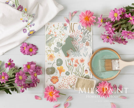 Stockholm Green Milk Paint by Homestead House with floral card, paintbrush, and pink flowers on white table.