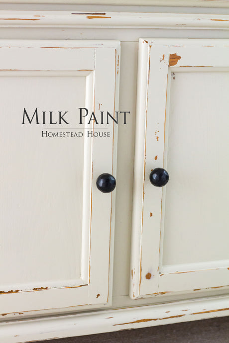 Cream-painted cabinet in Stone Fence Milk Paint by Homestead House with black knobs.