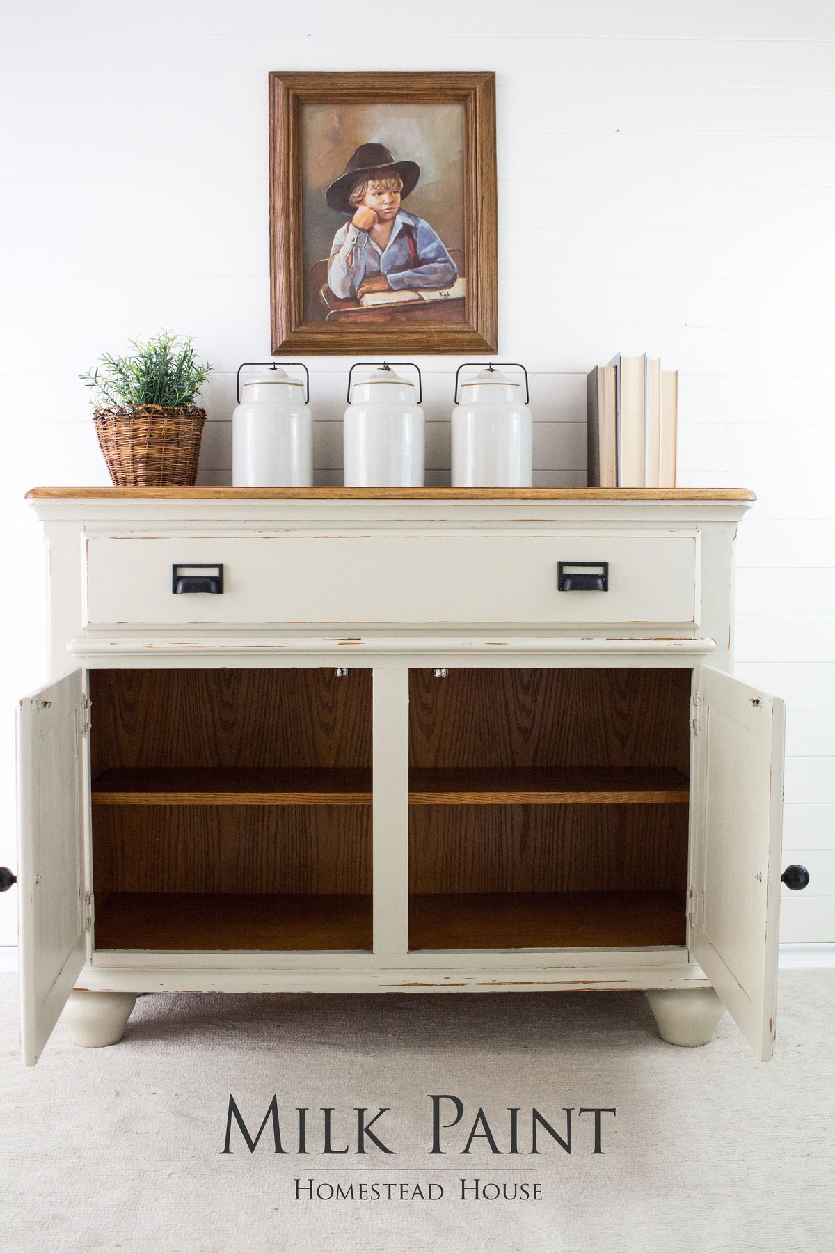 Cream sideboard painted in Stone Fence Milk Paint by Homestead House, styled with jars, books, and plant.