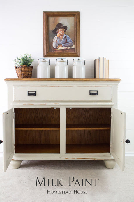 Cream sideboard painted in Stone Fence Milk Paint by Homestead House, styled with jars, books, and plant.