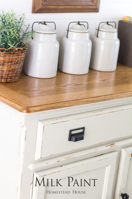 White canisters on a wooden-topped cream cabinet painted Stone Fence Milk Paint by Homestead House.