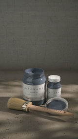 Two jars of Fusion Mineral Paint Storm Alchemy, one open, with a brush nearby.