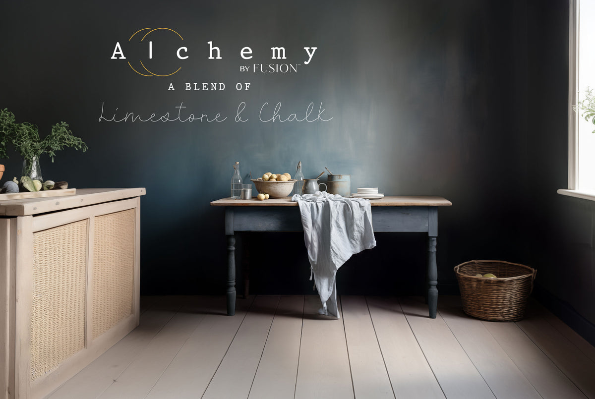 Rustic kitchen with dark table, fruit basket, linen, and wall painted in Storm Alchemy by Fusion Mineral Paint.