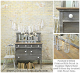 Gray dresser painted Suitcase by Old Fashioned Milk Paint with white knobs and glass bottles on top.