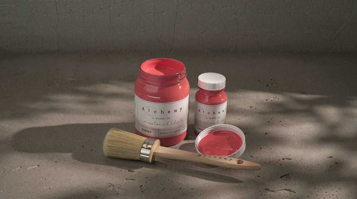 Open jar and small bottle of Sunset Alchemy Paint by Fusion Mineral Paint with brush, paint exposed.
