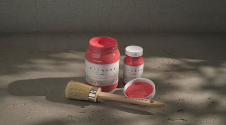 Open jar and small bottle of Sunset Alchemy Paint by Fusion Mineral Paint with brush, paint exposed.