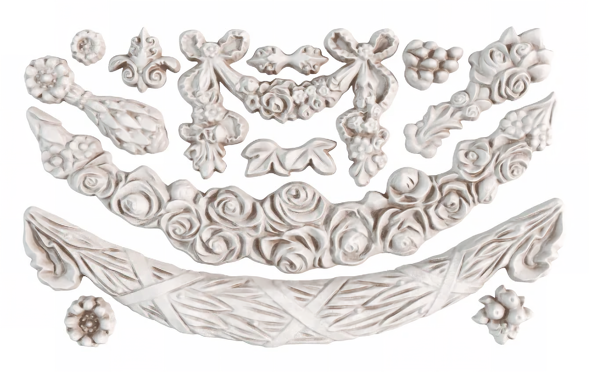 White appliques made with I.O.D. Swags Mould by Iron Orchid Designs, featuring flower, bow, and garland motifs.