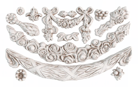 White appliques made with I.O.D. Swags Mould by Iron Orchid Designs, featuring flower, bow, and garland motifs.