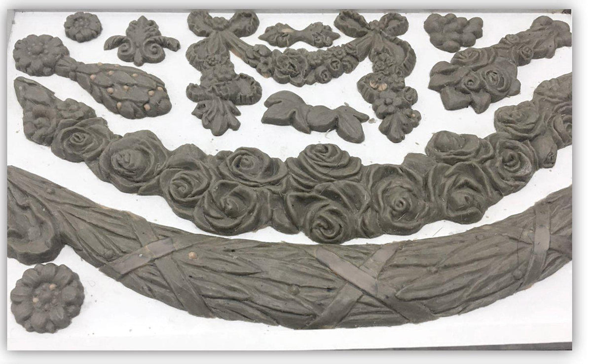 Clay floral designs made using the IOD Iron Orchid Designs Swags Mould displayed on a white background.