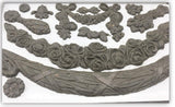 Clay floral designs made using the IOD Iron Orchid Designs Swags Mould displayed on a white background.