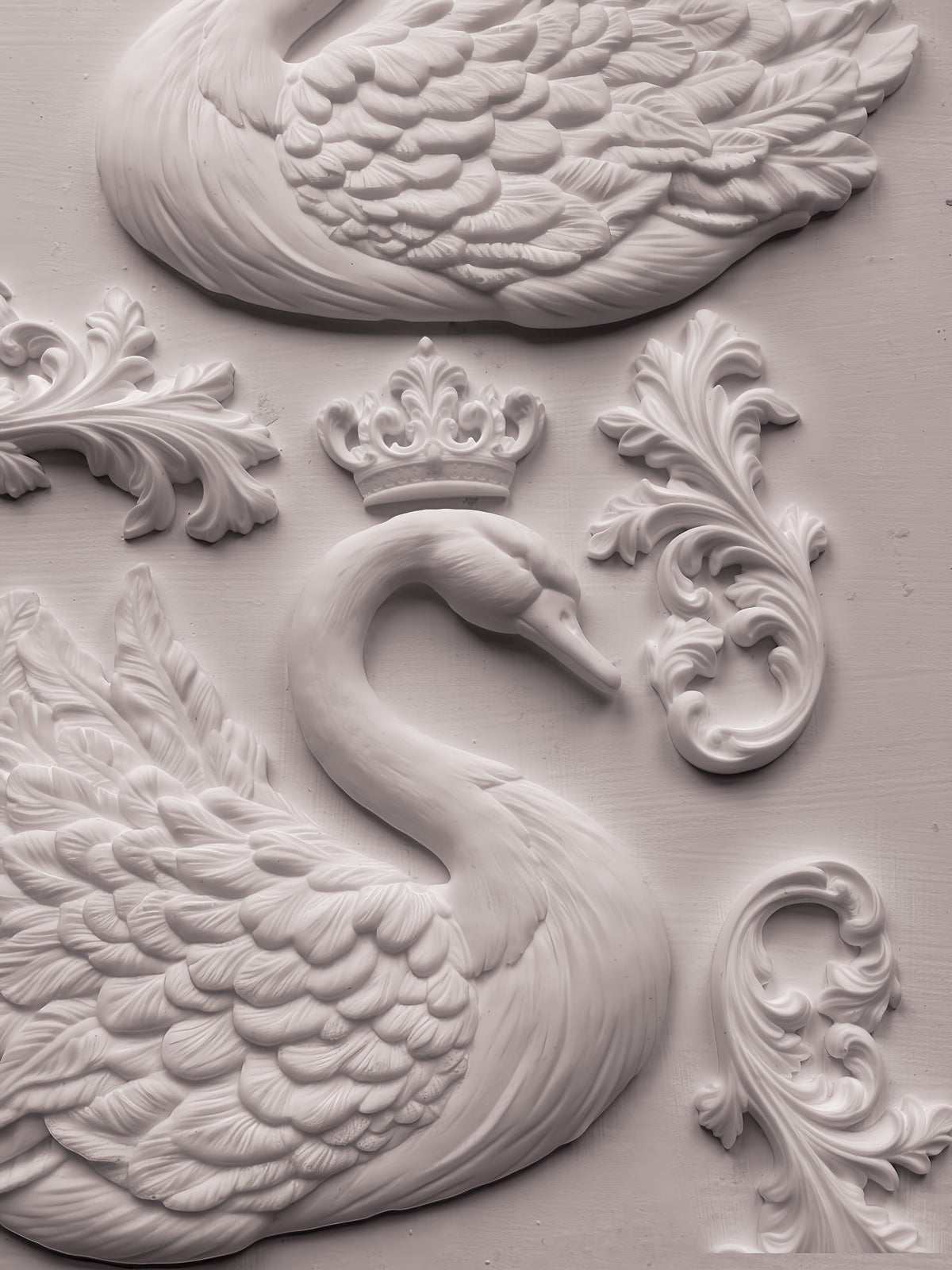 White swan relief with crown and ornate flourishes, made with IOD Swans Mould on a light textured background.