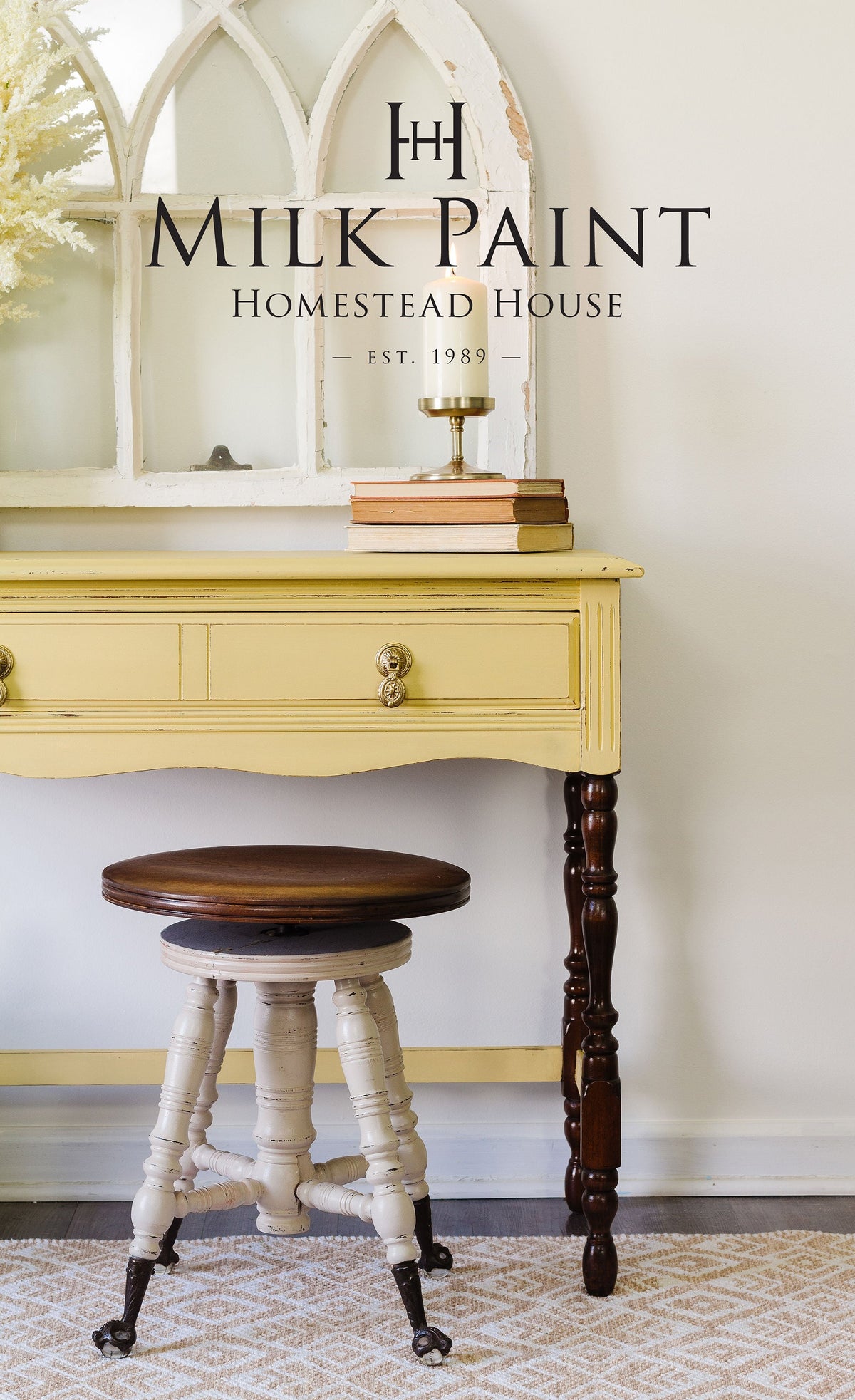 Desk in Homestead House’s Swedish Yellow Milk Paint with drawers and matching stool, shown beside arched window frame.