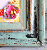 Distressed Sweetie Jane frame by Old Fashioned Milk Paint with paper flowers on a yellow background.