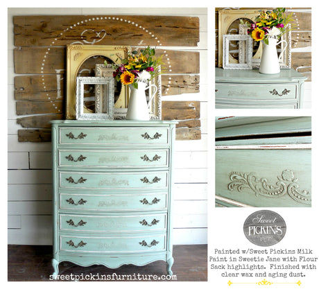 Blue vintage dresser in Sweetie Jane by Old Fashioned Milk Paint with ornate handles and flowers on top.