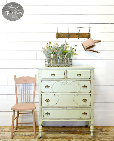 Pale green Sweetwater dresser by Old Fashioned Milk Paint next to a pink chair.
