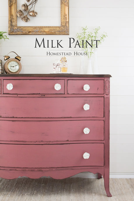 Red dresser painted in Texas Rose Milk Paint by Homestead House with white knobs.