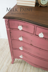 Pink dresser painted with Homestead House Texas Rose Milk Paint, white knobs, and brown top.