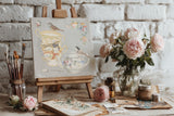 The Belgravia Transfer by I.O.D. features ornate vases, birds, and tableware on an easel with paintbrushes and flowers.