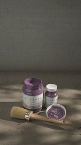 Three jars of Thistle Alchemy Paint by Fusion Mineral Paint, one open, with a paintbrush nearby.