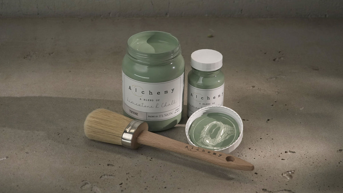 Large and small jars of Fusion Mineral Paint Thyme Alchemy, open lid, and brush displayed together.