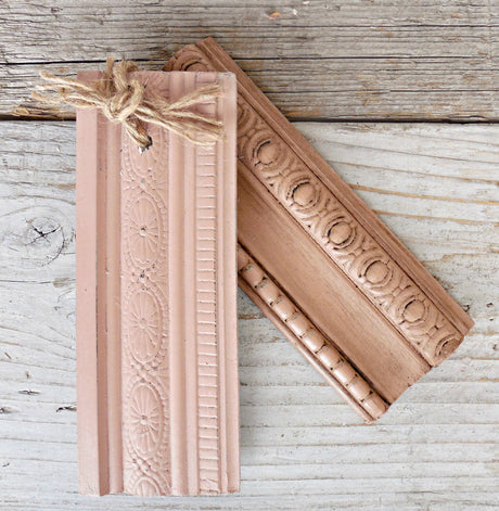 Two ornate wood trims in rustic finish with Tickled Pink by Old Fashioned Milk Paint; one features twine detail.