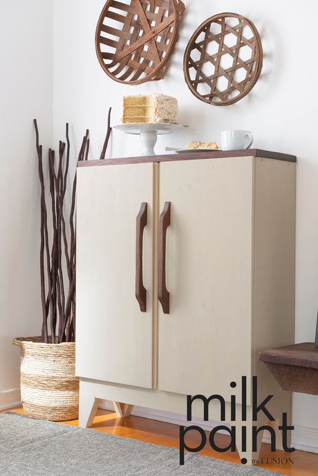 Cream cabinet with wooden handles, finished in Toasted Coconut Paint by Fusion Mineral Paint, natural accents shown.