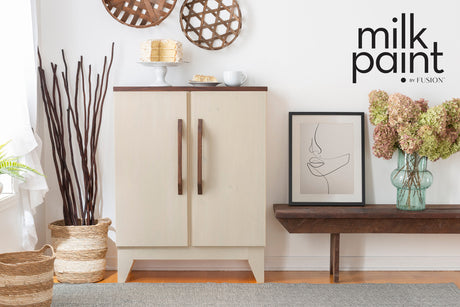 Cabinet painted in Toasted Coconut by Fusion Mineral Paint, with cake, flowers, and art near a bench.