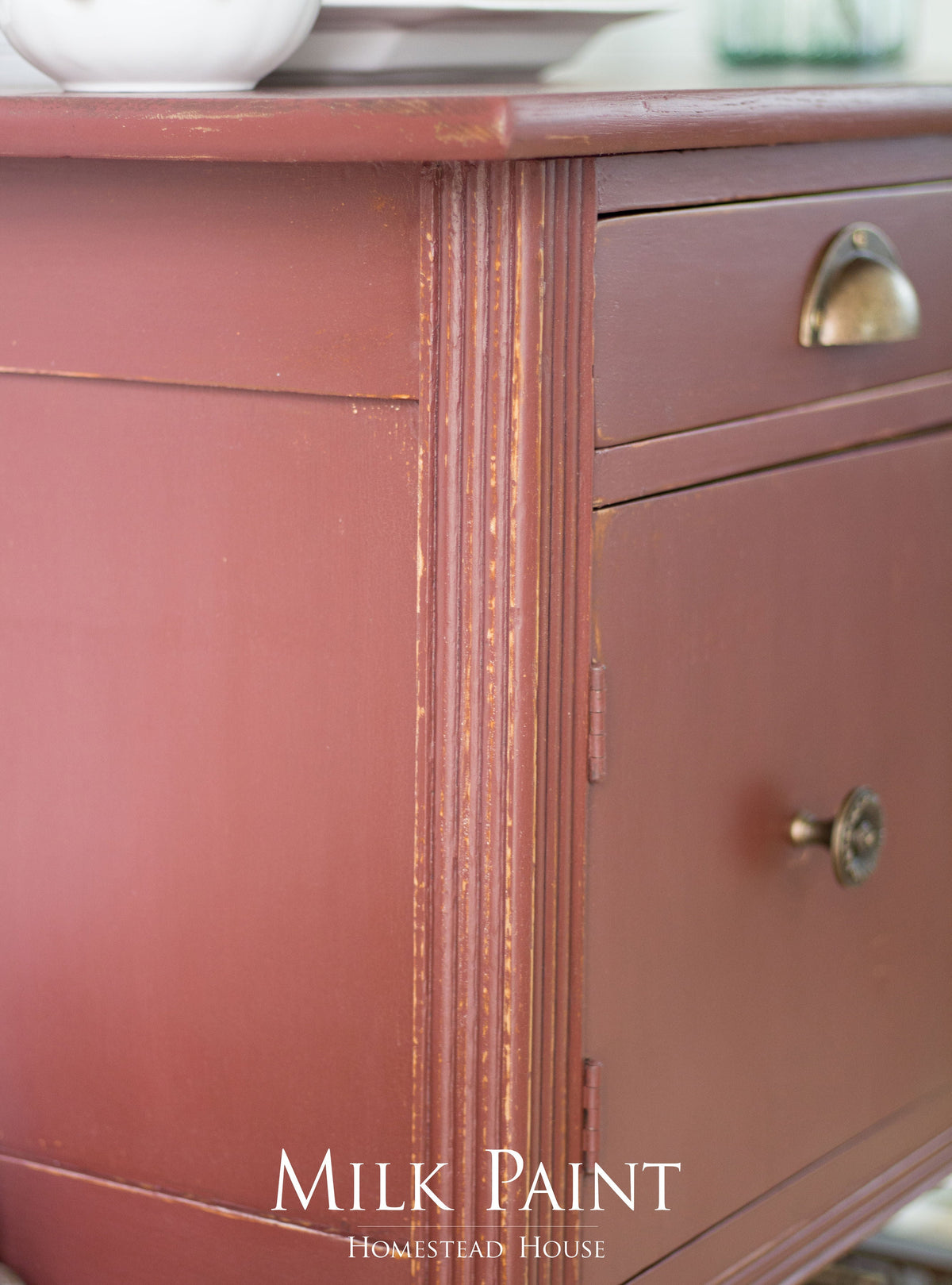 Red wood cabinet painted in Trading Post Red Milk Paint by Homestead House, brand name label visible.