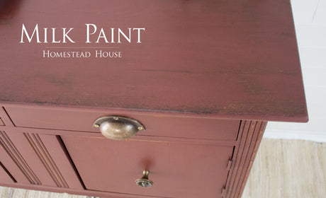 Cabinet in Trading Post Red Milk Paint by Homestead House with brass handles, “Milk Paint Homestead House” above.