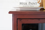 Cabinet in Trading Post Red Milk Paint by Homestead House with plate on top and product name text visible.