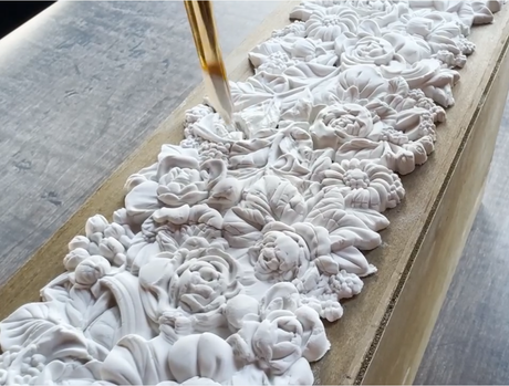 Paintbrush applying clear liquid to white floral relief made with Trimmings 4 Mould by I.O.D.