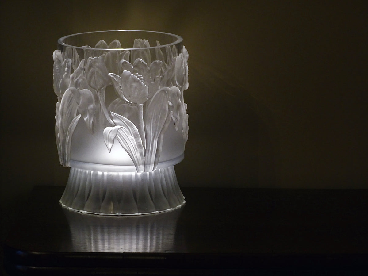 I.O.D. Tulips Mould vase by Iron Orchid Designs on dark wood, illuminated softly from below.