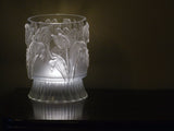 I.O.D. Tulips Mould vase by Iron Orchid Designs on dark wood, illuminated softly from below.
