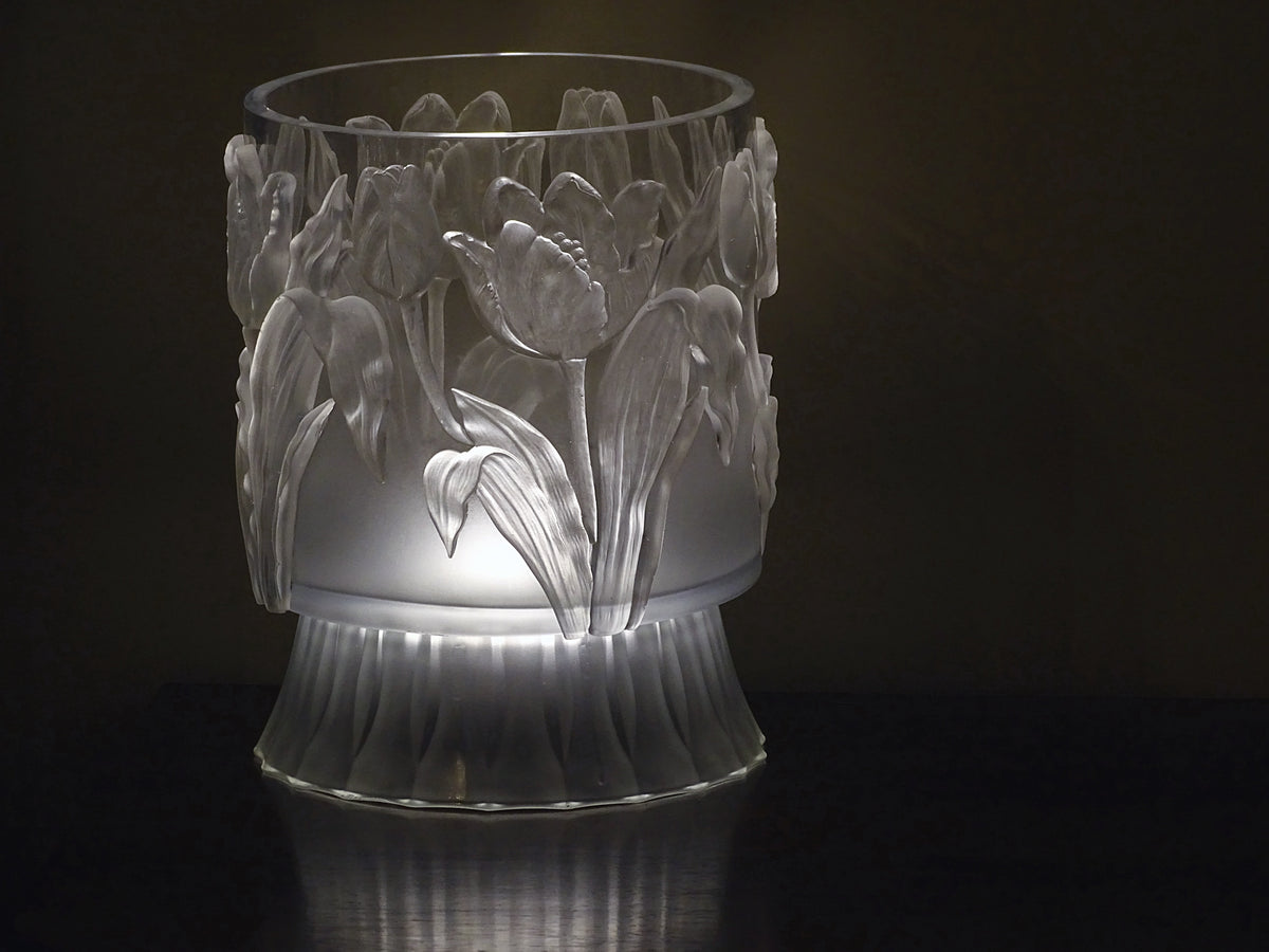 Frosted vase featuring I.O.D. Tulips Mould decor, illuminated from below on a dark reflective surface.