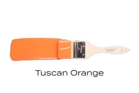 Paintbrush coated with Fusion Mineral Paint Tuscan Orange (Seasonal) on a plain white background.