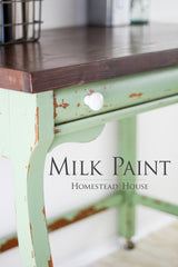 Distressed green table in Upper Canada Green Milk Paint by Homestead House, white knob, dark top.