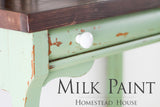 Distressed wooden table with Upper Canada Green Milk Paint by Homestead House, shown in close-up.
