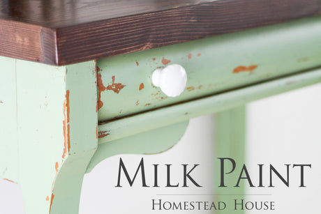 Distressed wooden table with Upper Canada Green Milk Paint by Homestead House, shown in close-up.