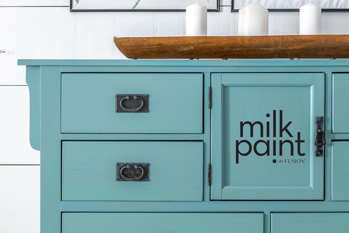 Teal cabinet with black handles painted in Fusion Mineral Paint Velvet Palm, candles on a wooden tray on top.