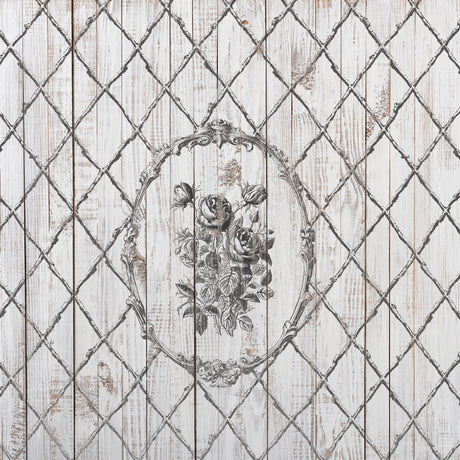 The Veranda Stamp by I.O.D. with a black floral design in an ornate oval over bamboo lattice wooden planks.