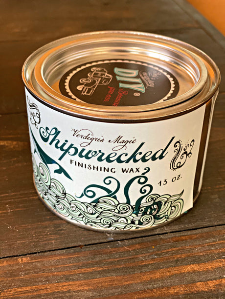 DIY Paint Co. Verdigris Shipwrecked Wax can with waves and ship label on a wooden surface.