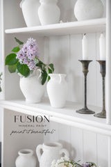 White ceramic vases and candlesticks in white, lilac, and Victorian Lace Fusion Mineral Paint on white shelves.