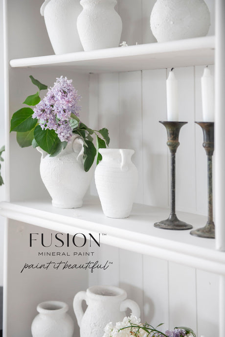 White ceramic vases and candlesticks in white, lilac, and Victorian Lace Fusion Mineral Paint on white shelves.