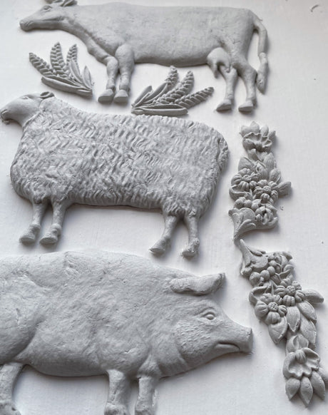 White relief depicting farm animals and wheat, made with Village Market Mould by Iron Orchid Designs (IOD).