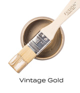 Brush with metallic paint on open Fusion Mineral Paint can, Vintage Gold Metallic shade.