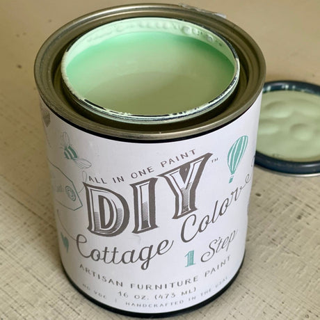 Open can of Vintage Mint DIY Cottage Color by DIY Paint Co., lid beside container on beige surface.