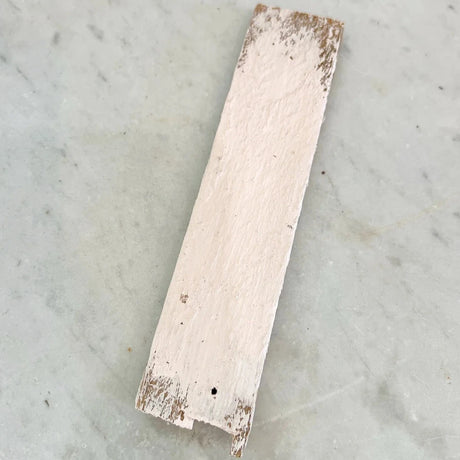 Rectangular wood sample painted Vintage Pink DIY Cottage Color by DIY Paint Co. on gray marbled surface.