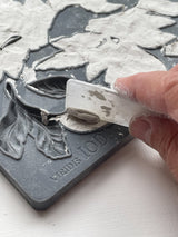 Hand removes clay from I.O.D. Viridis Mould using white tool on gray FREDIS TOOLS tray.